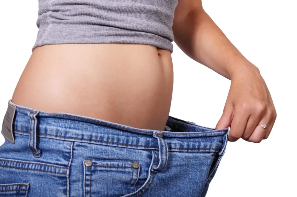 もち麦ダイエット ほっそりした女性のお腹 ぶかぶかのジーンズ